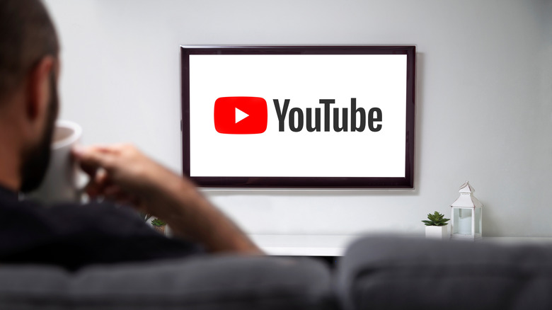 A man looking at a TV with the YouTube TV logo