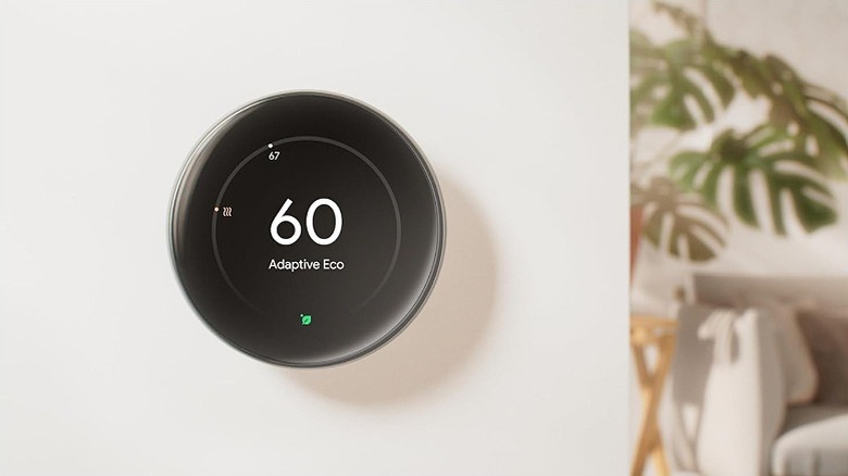 Black thermostat tuned into Adaptive Eco mode placed on a wall.