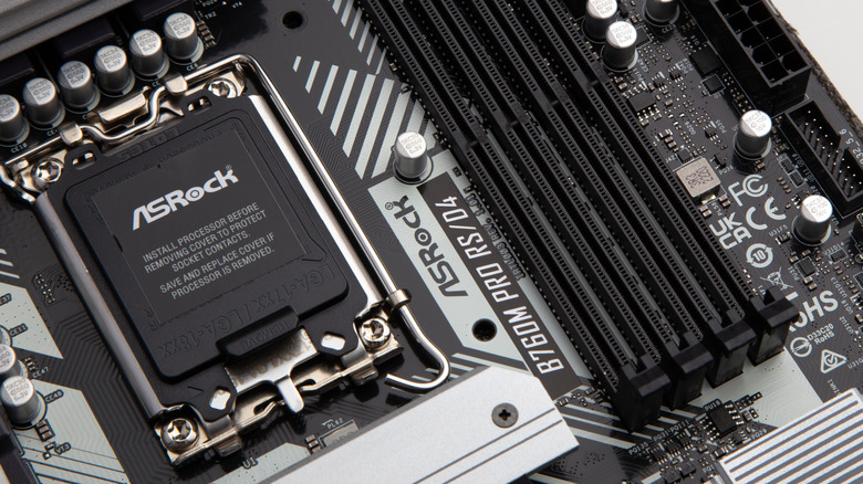 Close up of the CPU socket on a silver and black ASRock motherboard.