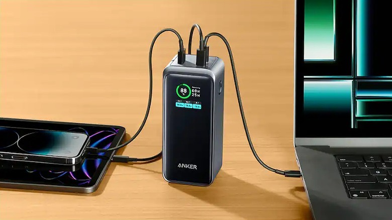 Power bank connected to smartphone, tablet, and laptop.