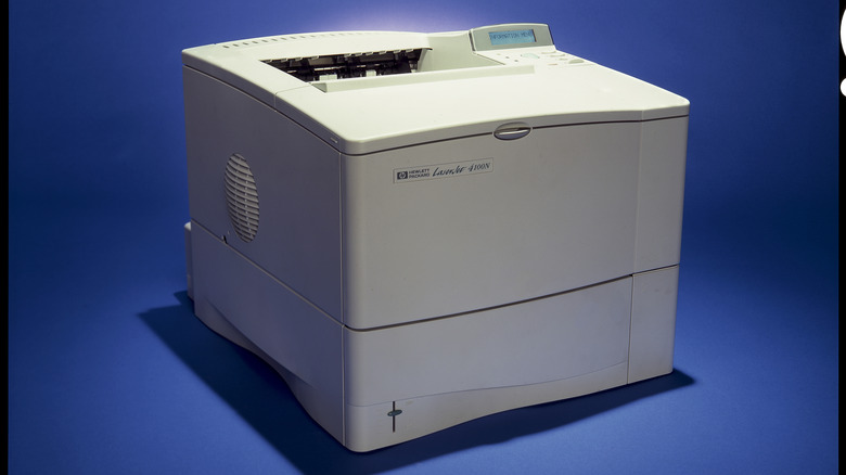 A vintage HP LaserJer printer on a blue background.
