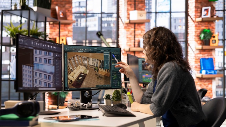 A person twisting their neck to look at a secondary monitor