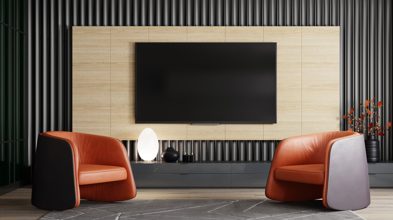 A depiction of a modern home theater room with a wall-mounted TV and two seats