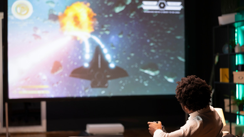 A person playing video games on their projector
