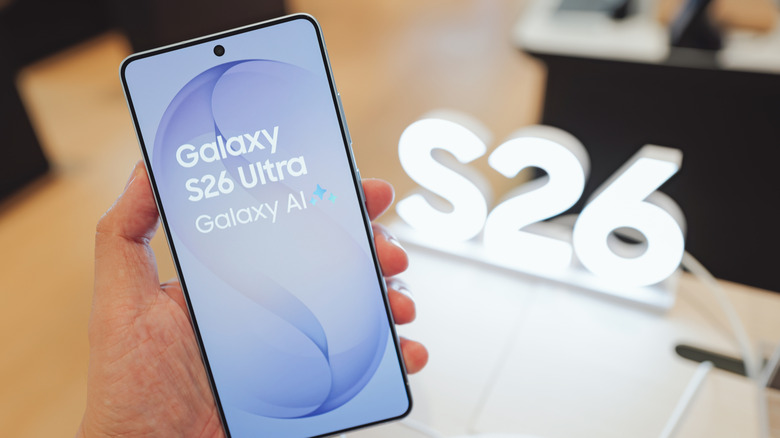 Holding the Samsung Galaxy S26 Ultra in front of an S26 sign