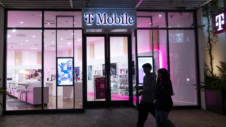 People walking by a T-Mobile store.