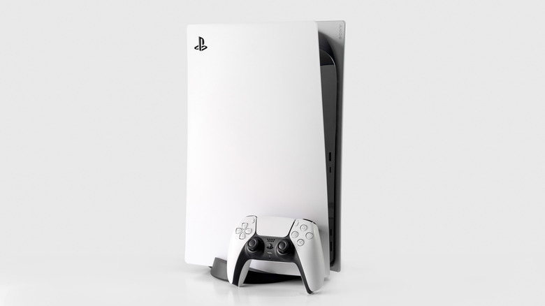 A PlayStation 5 with a white DualSense controller against a white background