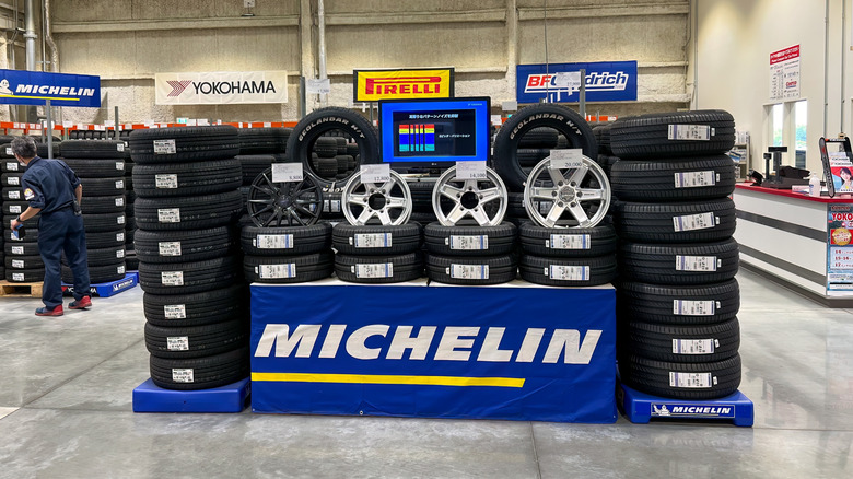 Different brands of tires in a Costco Tire Center, with Michelin tires in the foreground.