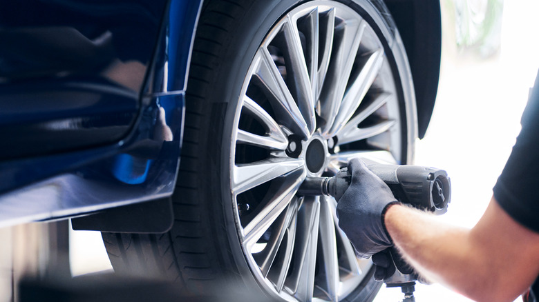 A mechanic installing a tire on a vehicle.
