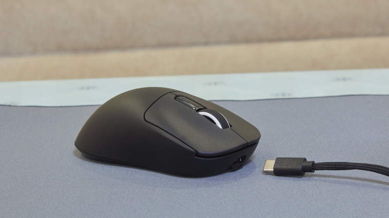 A wireless gaming mouse with a USB cable beside it.
