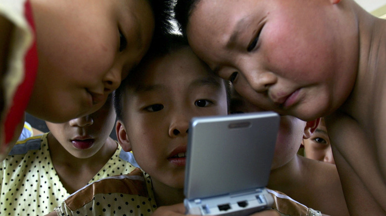 Chinese children playing on a Game Boy