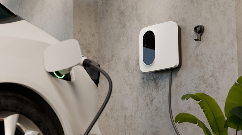 An electric car charging at home with a residential charger.