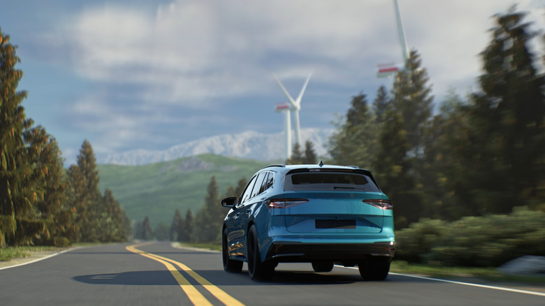 An electric car driving along a stretch of highway.