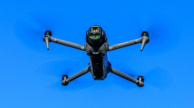 The DJI Mavic 4 Pro in flight against a blue sky