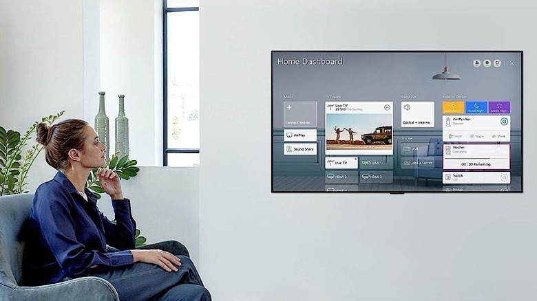 Woman watching a LED TV screen showing the home dashboard.