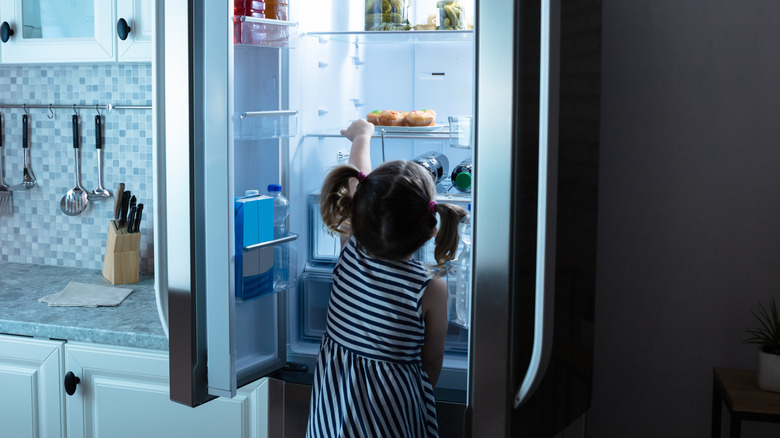 Little girl taking food from the refridgerator