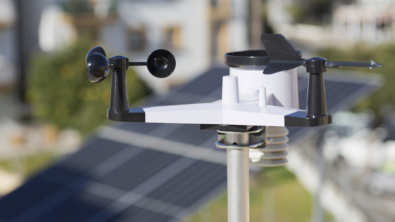 Residential weather station with solar panels in the background