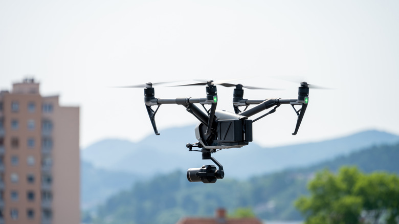 A drone flying over a city with distant mountains.