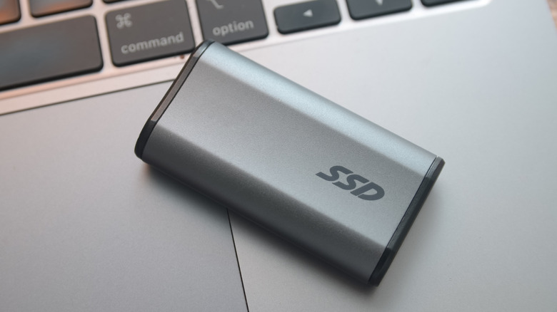 A portable external SSD placed on a laptop