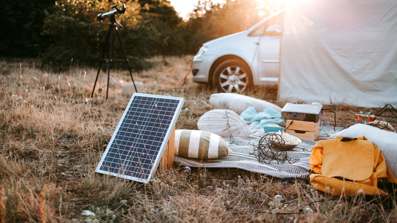 A portable solar and projector setup on a camping site