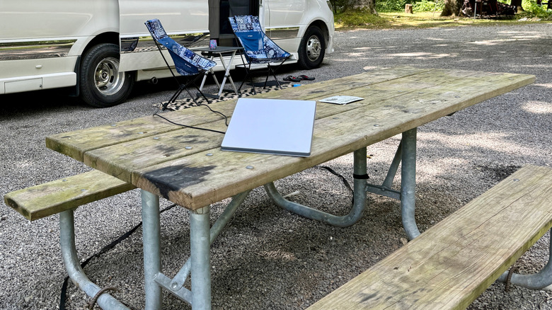 Starlink mini router placed on a table outdoors next to a parked RV