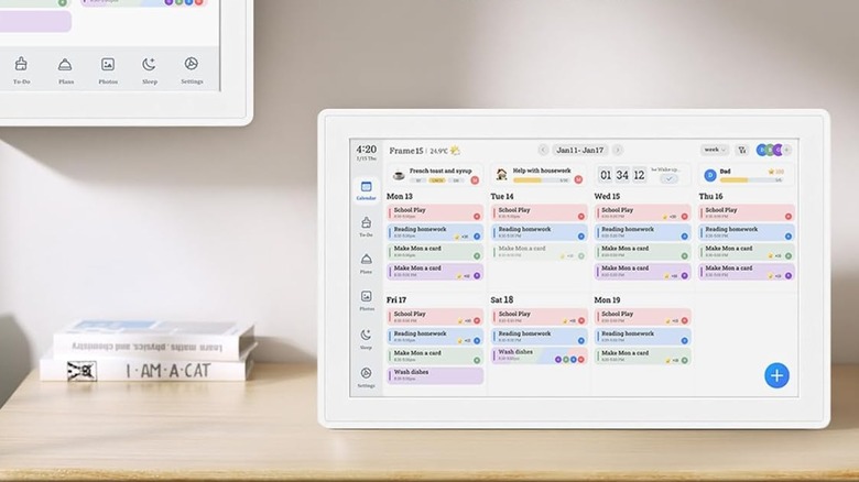 A Yemsd digital calendar sitting on a wooden table with a stack of books.