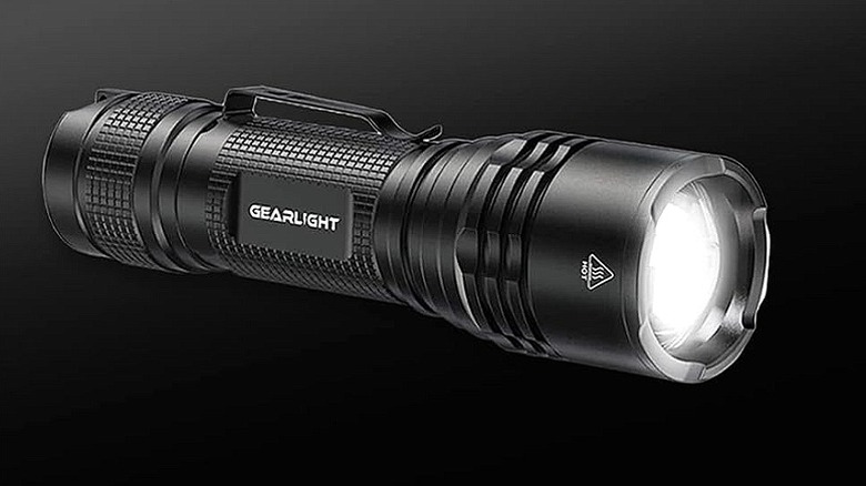 A black LED GearLight flashlight against a black background