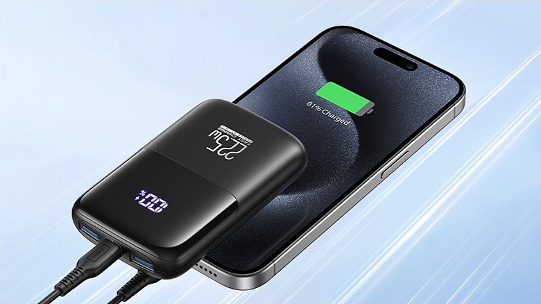 A smartphone plugged into an Iniu portable charger.