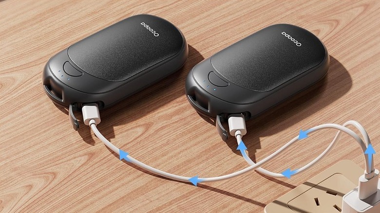 Two Ocoopa hand warmers plugged into a charger