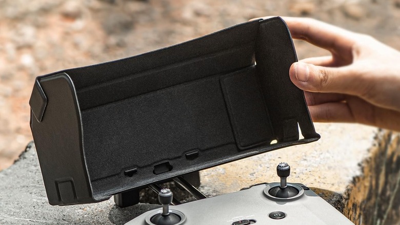 A close-up image of a drone remote controller with a foldable sun hood.