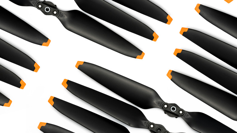 A collection of drone propellers laid out against a plain background.