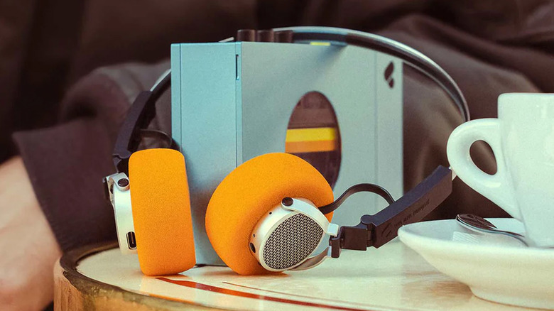A We Are Reward cassette player with retro-inspired headphones on a table.