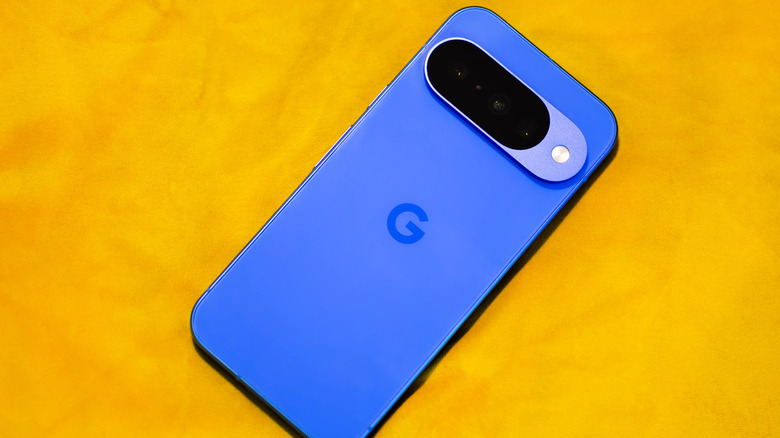 The back of the Google Pixel 10, placed on a yellow surface.