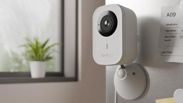 The Synology CC400W security camera attached to the wall inside a home.