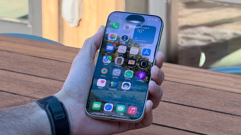 A hand holding an iPhone with the new Siri AI UI