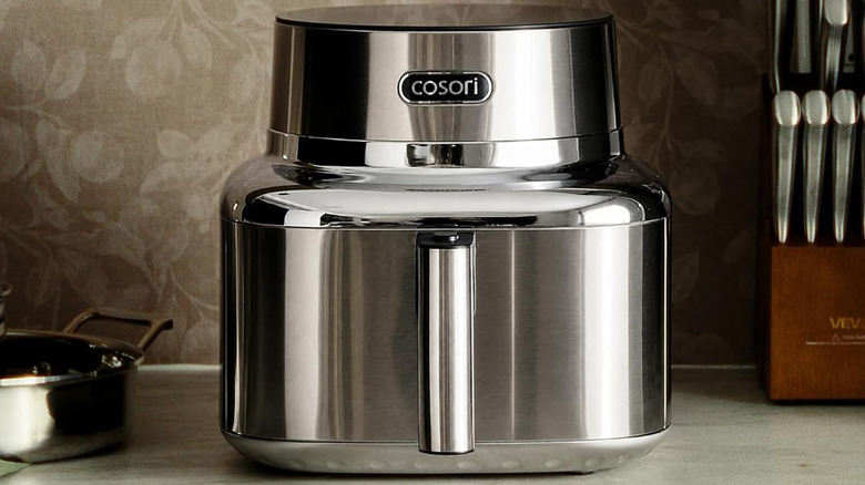 A Corosi Iconic Air Fryer on a kitchen counter next to a knife block.