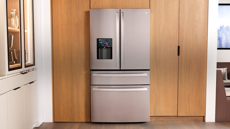 A GE Profile Smart Refrigerator with Kitchen Assistant in a wood and white kitchen.