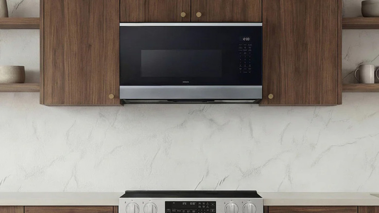 A Samsung over-the-range microwave near wood cabinets.