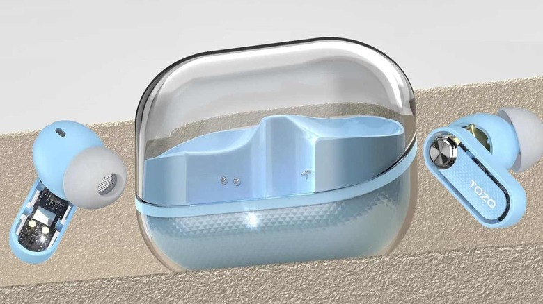 A pair of light blue Tozo Crystal Pods on a ledge placed on either side of their carrying case.