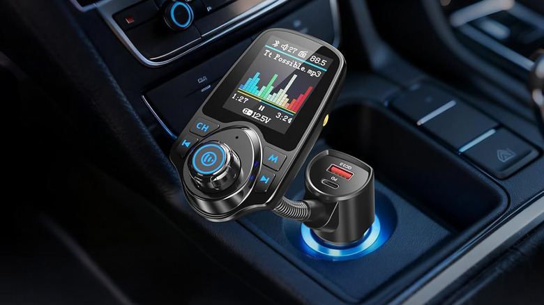A Nulaxy Bluetooth car adapter in the center console of a car.