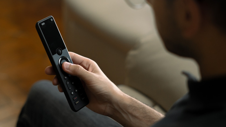 A person holding the Sofabaton X1S universal remote