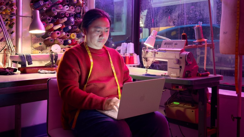 A tailor using the MacBook Neo in their shop