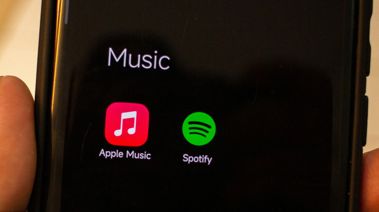 The app icons for Apple Music and Spotify on a phone.