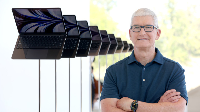 Apple CEO Tim Cook stands next to a display of newly redesigned MacBook Air laptop during the WWDC22 at Apple Park