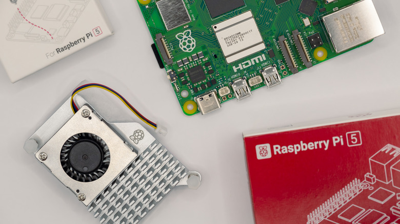 An image of the official Raspberry Pi 5 active cooler next to the Raspberry Pi 5 and their respective boxes..