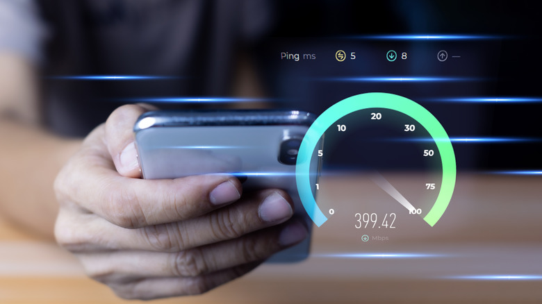 Hand holding a smartphone with an overlaid speed test interface showing high download speed, low ping, and fast network performance.
