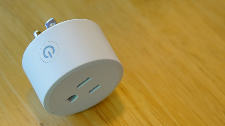 A smart plug on its side, showing the power button