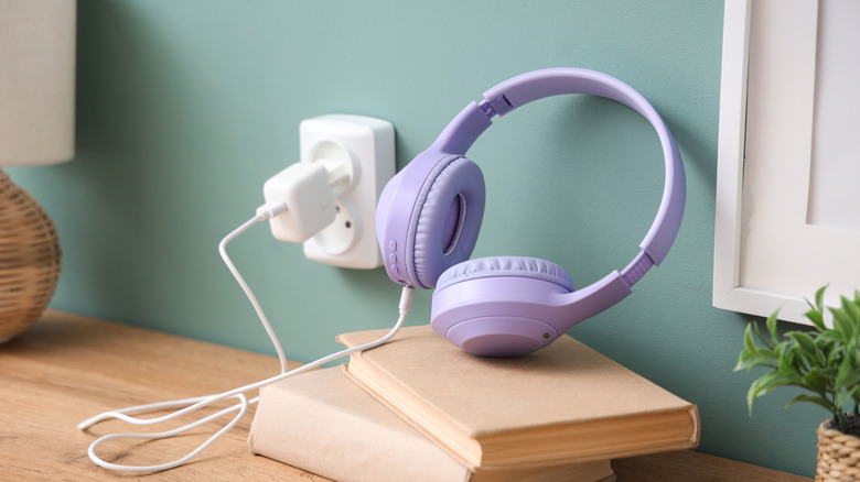 A pair of headphones plugged into a wall socket.