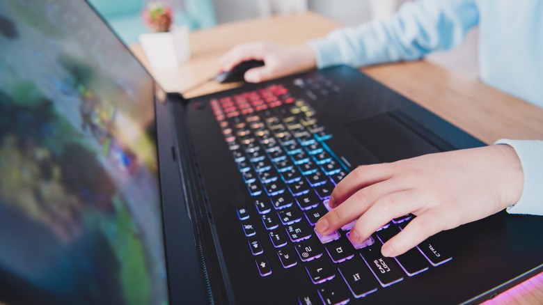 A person playing a game on a gaming laptop.