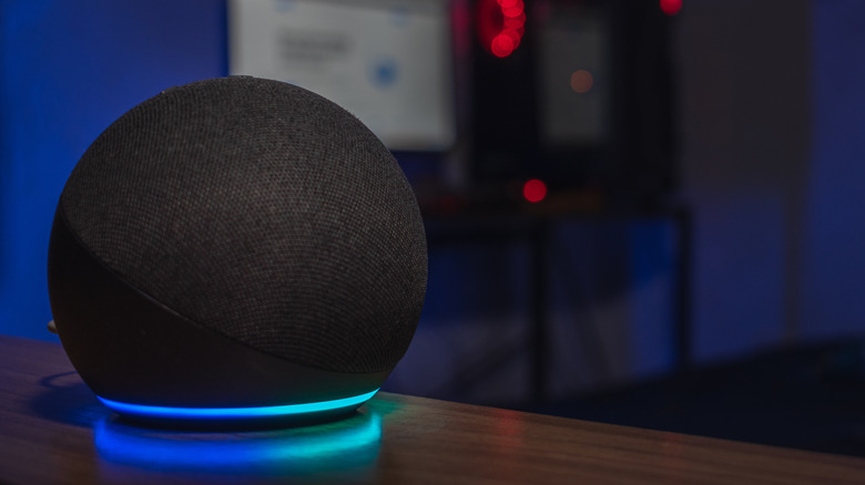 A close-up of an Amazon Echo smart speaker on a desk.